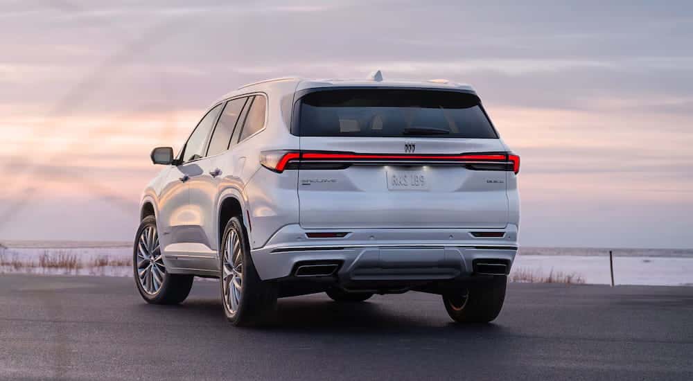 Rear of a white 2026 Buick Enclave parked near a lake.