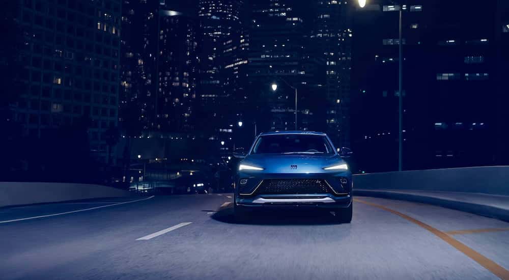 Front of a blue 2026 Buick Envista driving down a road.