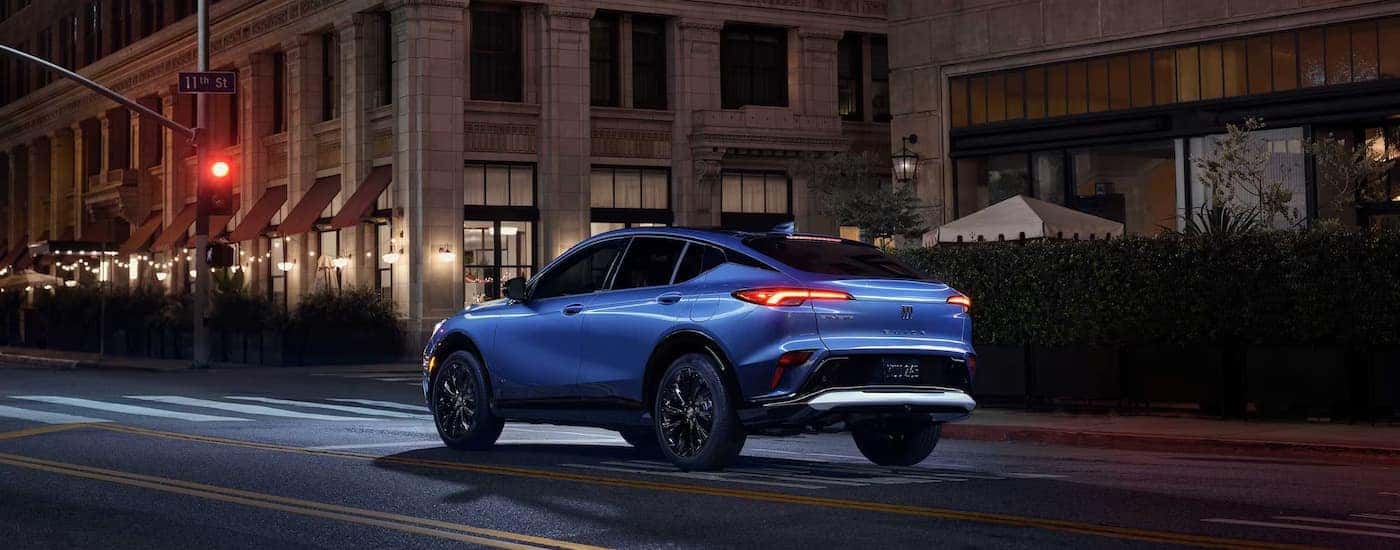 A blue 2026 Buick Envista driving on a city street at night