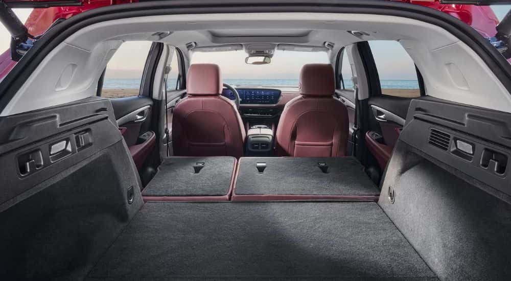 A red 2026 Buick Envision interior shown from the rear with seats down.