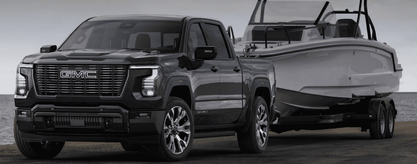 A black 2027 GMC Sierra 1500 towing a boat