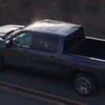 A gray 2027 GMC Sierra 1500 driving on a highway.