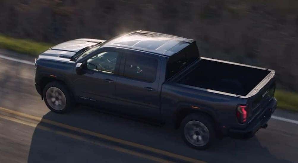 A gray 2027 GMC Sierra 1500 driving on a highway.