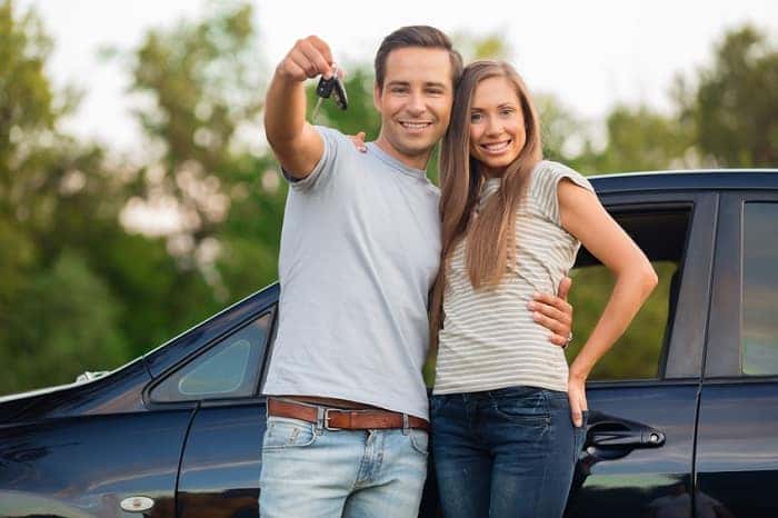 Couple Holding Keys to New Car