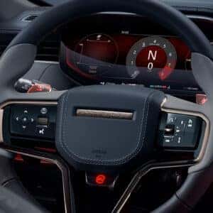 Range Rover Sport digital instrument cluster and steering wheel showing touch controls and red performance display theme