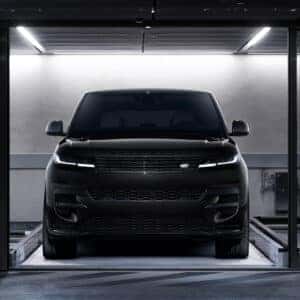 Front view of black Range Rover Sport in testing facility with modern LED lighting signature