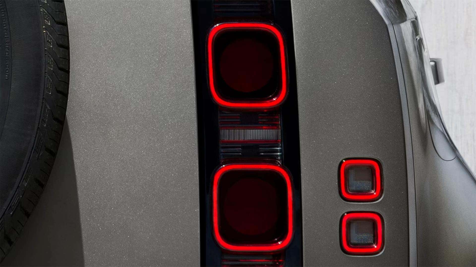 Close-up of Land Rover Defender tail lights showing square LED lighting elements with red illumination