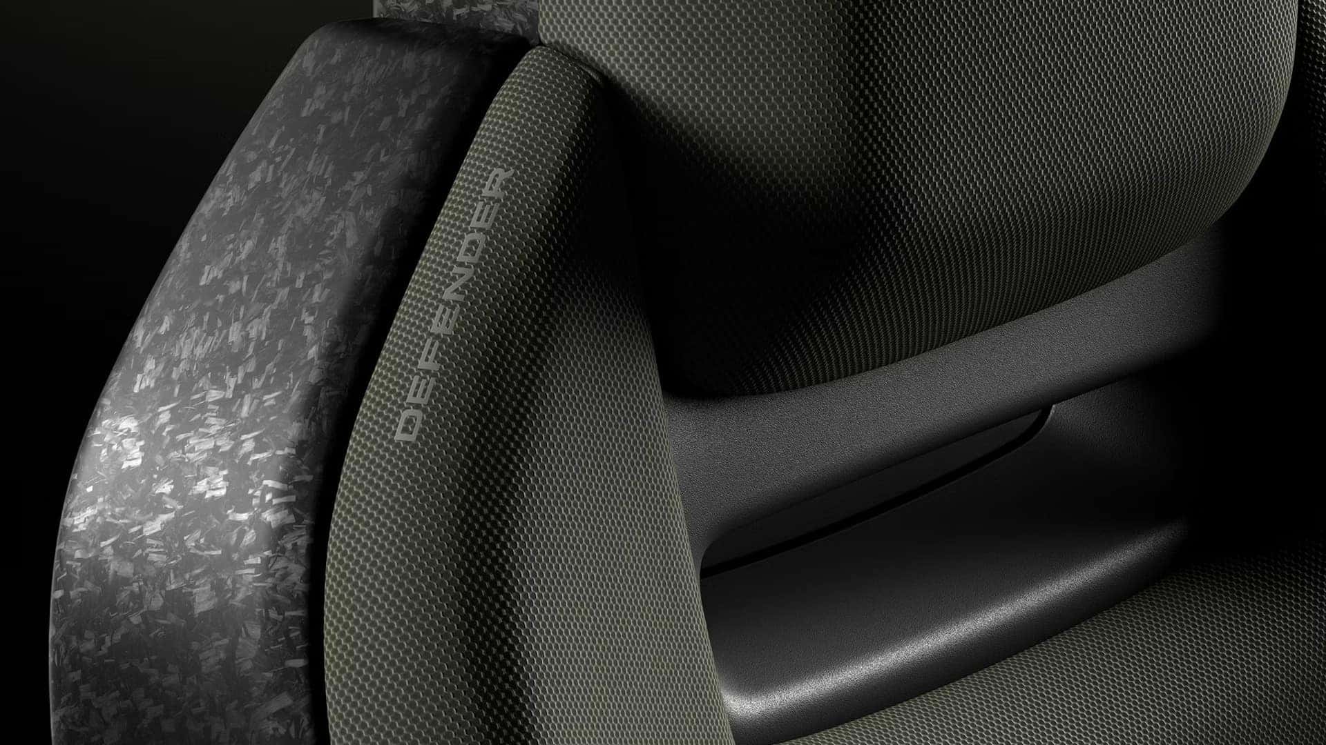 Close-up of seat material in Land Rover Defender showing textile pattern and "DEFENDER" embossed detail
