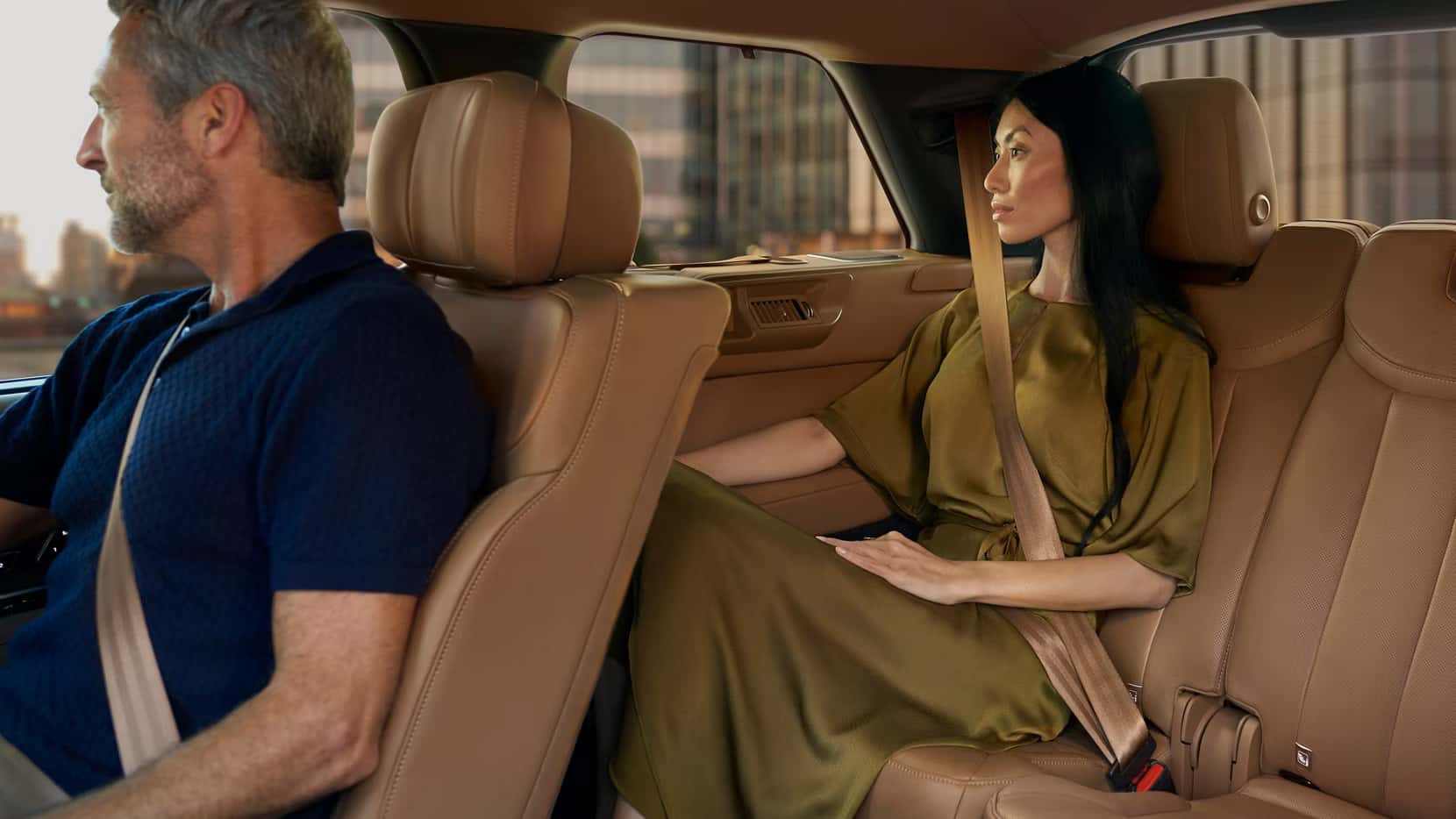 a man in the passenger front seat with a woman in the backseat in a range rover