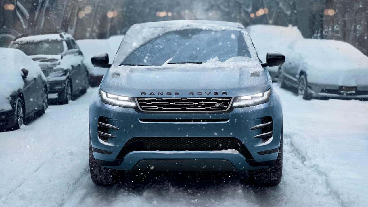 front view of a 2026 range rover evoque driving in the city in the snow