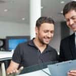 Young man with a salesman in a motor show