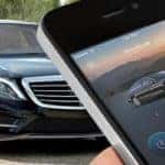 Hand holding smartphone with Mercedes-Benz mbrace application on screen
