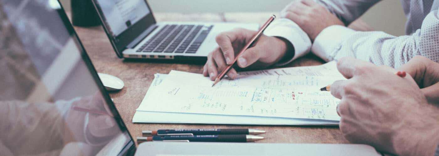 Man with pen in hand writing on paper 
