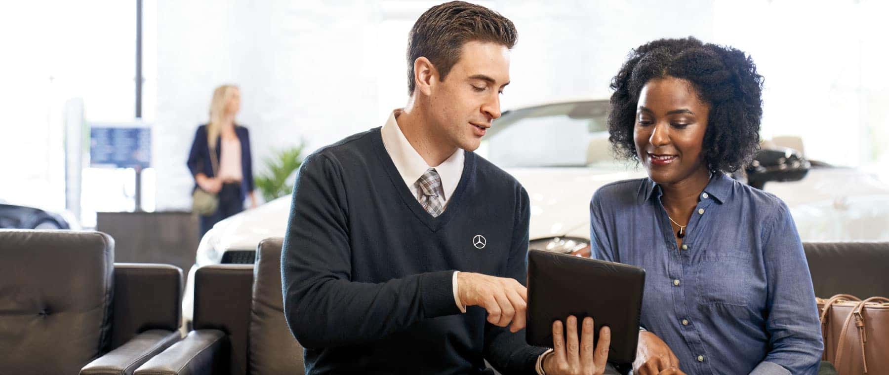Mercedes-Benz rep showing woman car options on an IPad