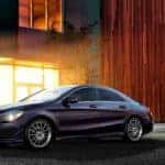 Black Mercedes-Benz CLA parked in front of a building at night