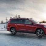 Red GLS driving on a snowy road at sunset