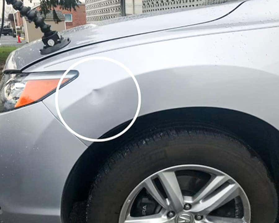Vehicle with minor dent before paintless dent repair