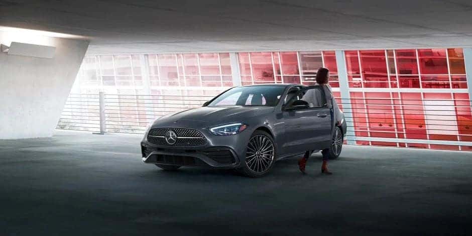 Woman standing by C-Class sedan