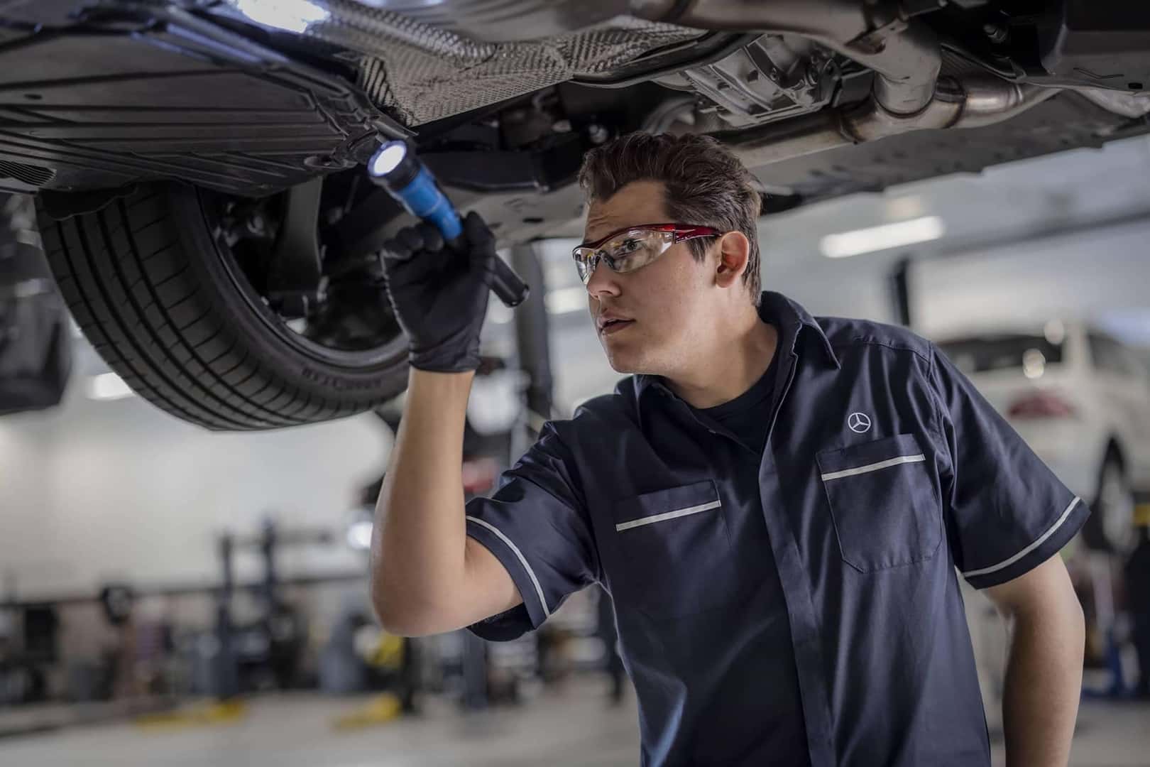 mercedes benz technician inspecting vehicle