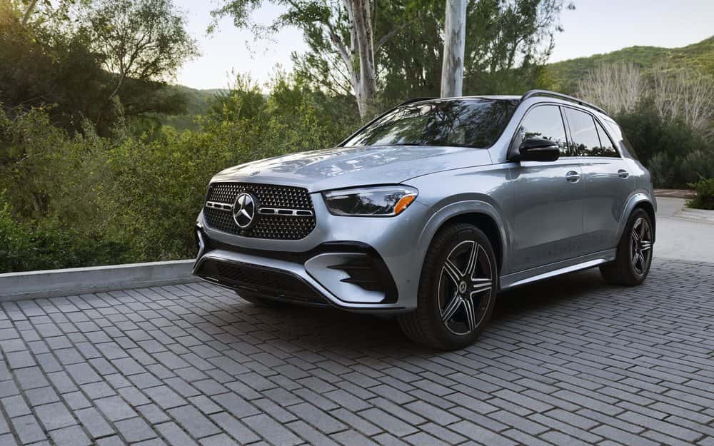 2026 Mercedes-Benz GLE 450 4MATIC SUV in silver, front three-quarter view on a stone driveway (Mercedes-Benz USA photo). Optional equipment shown.