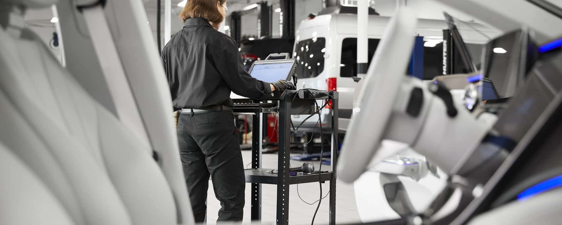 Mercedes-Benz technician running a vehicle diagnostic in the service bay