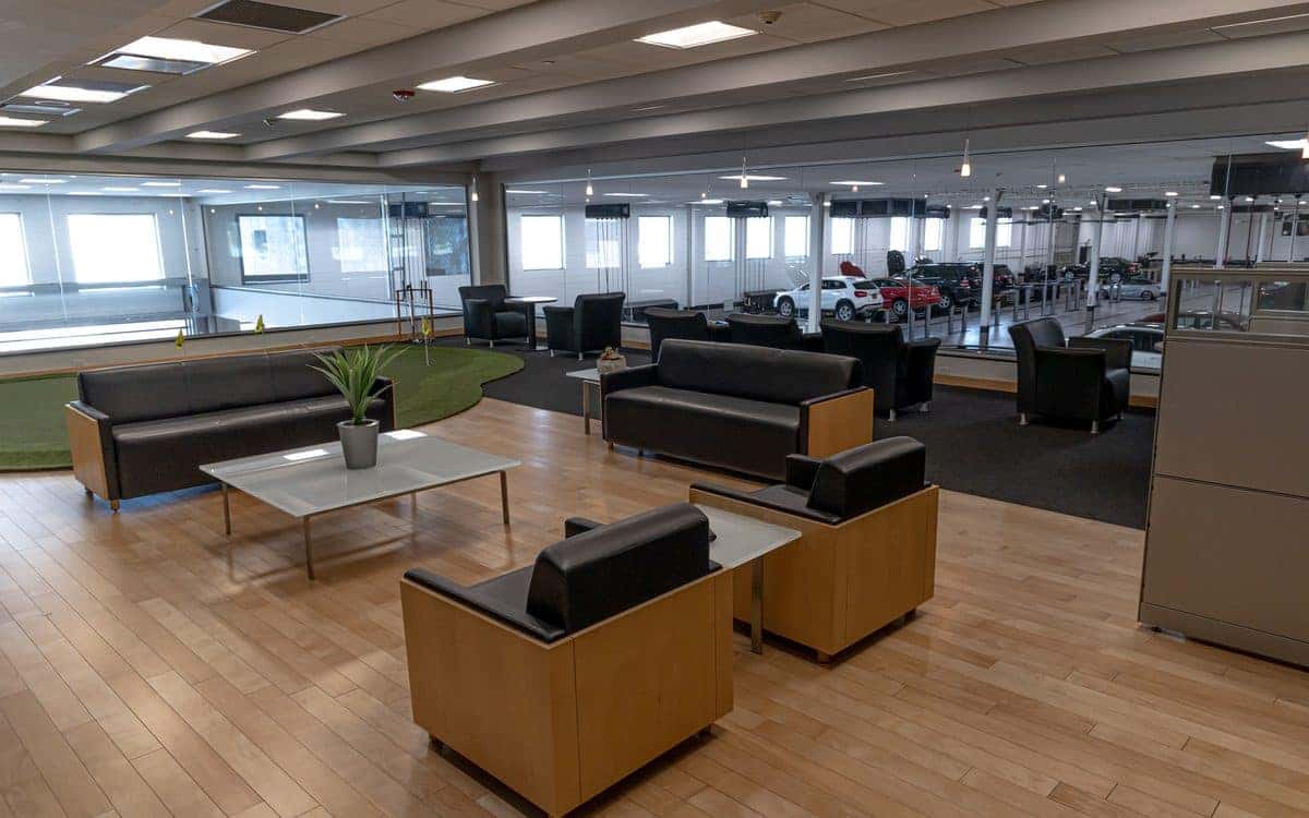 Customer lounge at the Mercedes-Benz of Rockville Centre Service Center with leather seating and an indoor putting green