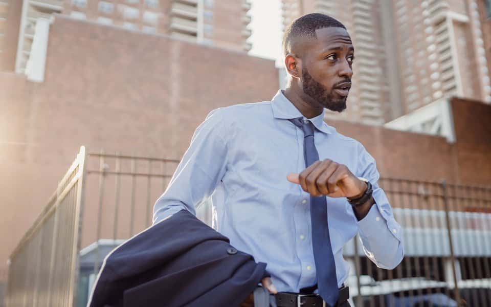 Man in a suit checking the time on his wristwatch