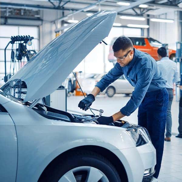 service man checking under vehicle hood
