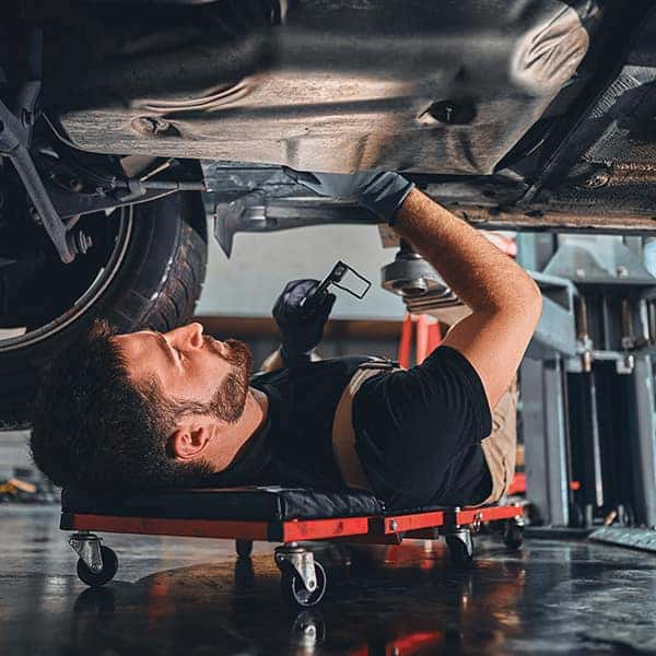 service man under vehicle