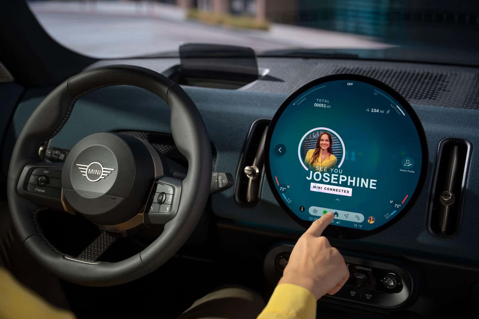 mini cooper rounded infotainment display with a driver using the touchscreen