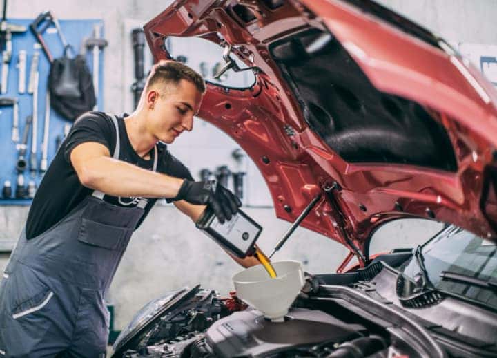 a service tech changing the oil in a MINI Cooper vehicle