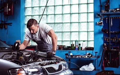 Certified technician diagnosing a modern vehicle engine block