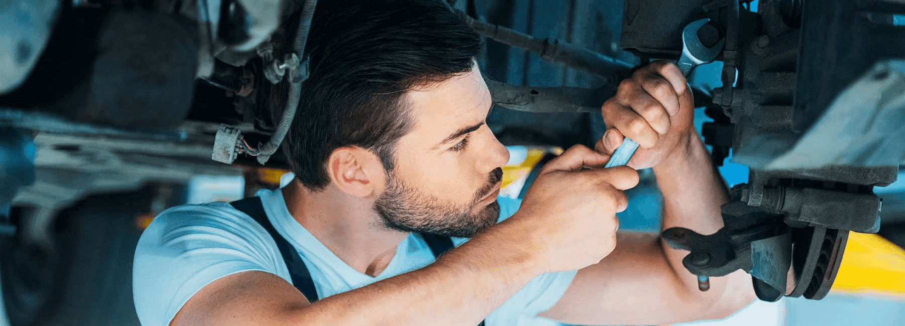 Certified auto technician servicing a vehicle inside a modern repair center