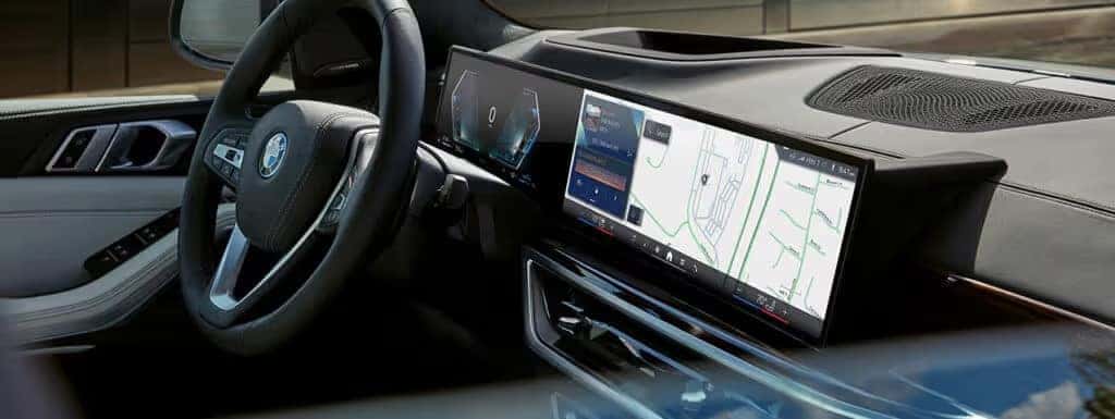 2025 BMW X5 interior cockpit view highlighting curved display with navigation and vehicle controls