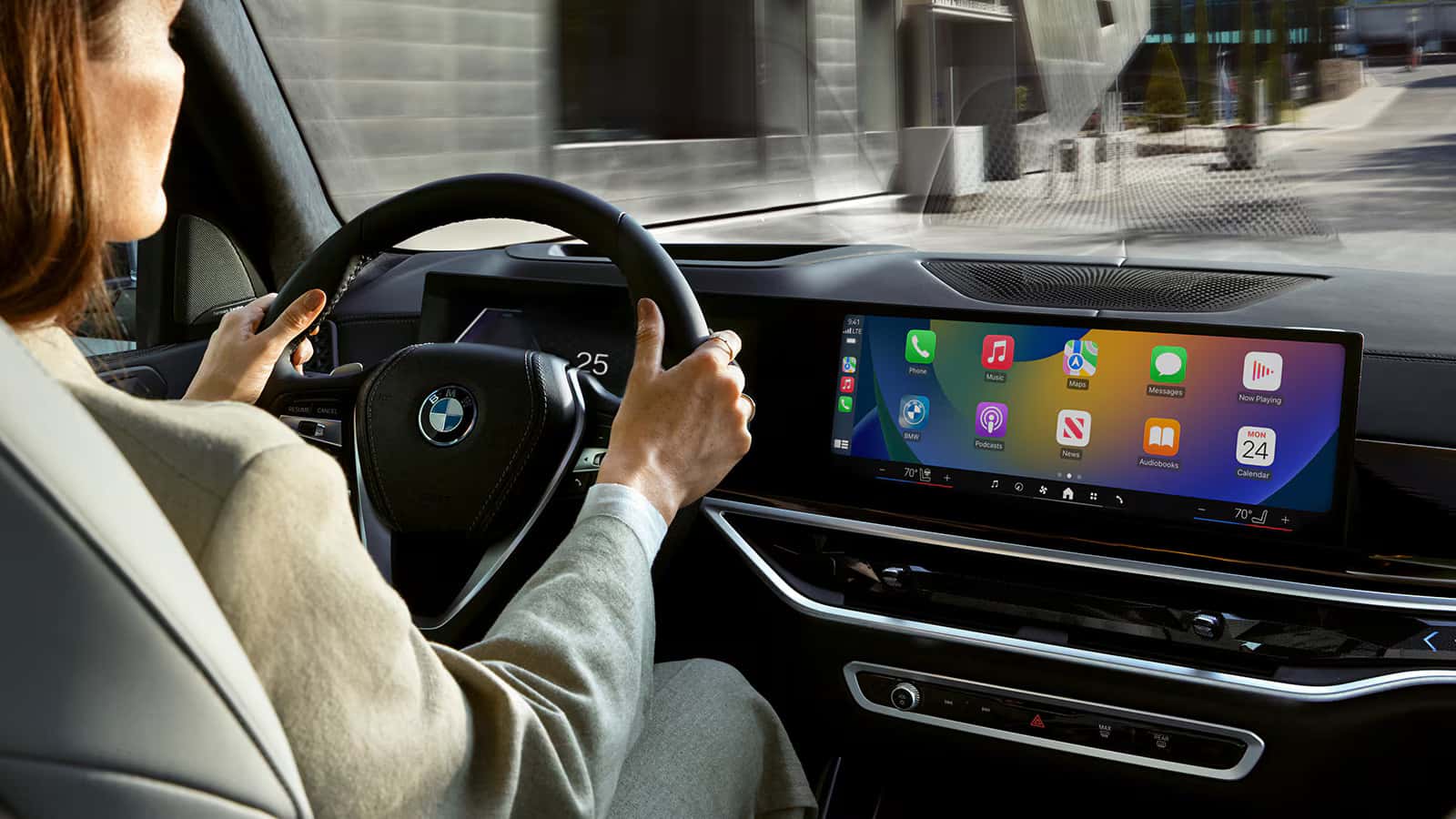 a woman driving a 2026 bmw x5 showcasing the interior infotainment system.