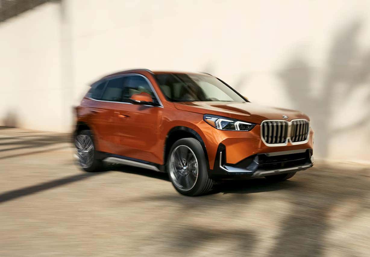 a bmw x1 parked next to a white wall