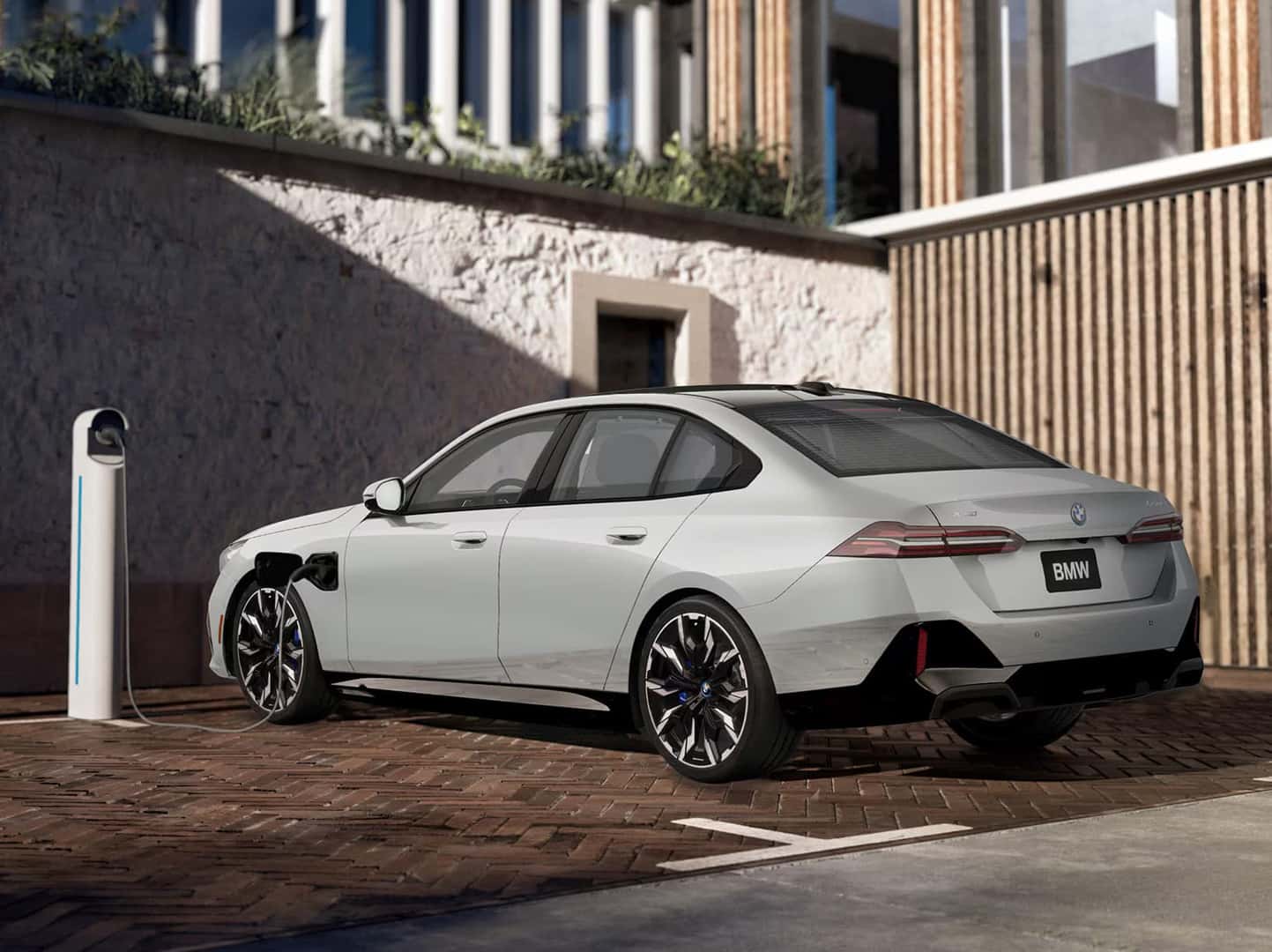 a white bmw i5 charging at a charging station