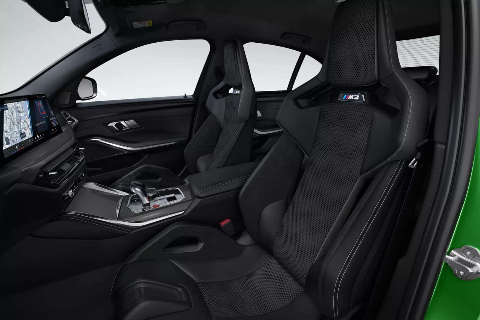 Front interior view of the 2025 BMW M3 showing carbon bucket seats with M3 badging and a modern digital cockpit.