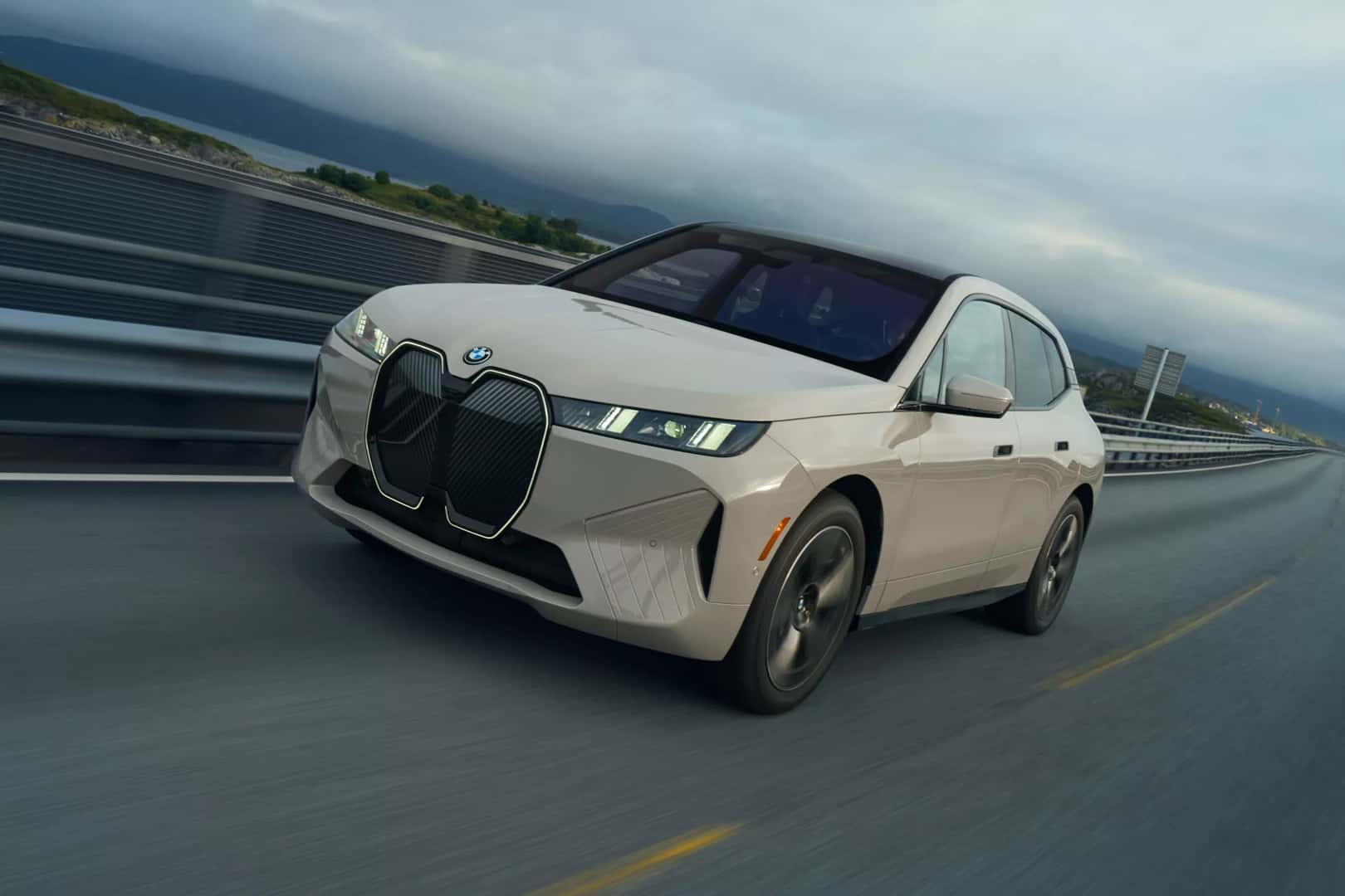 a white bmw ix driving on a highway