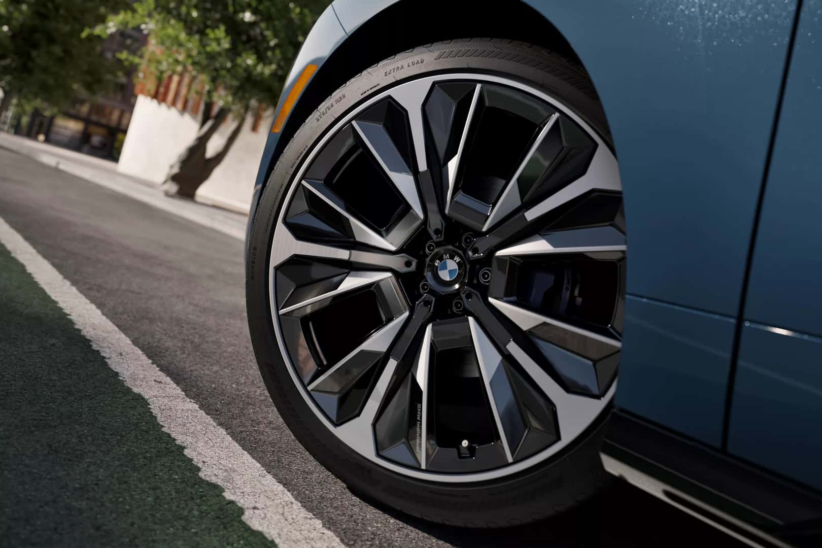 close up of the front driver's tire on a blue 2026 bmw ix