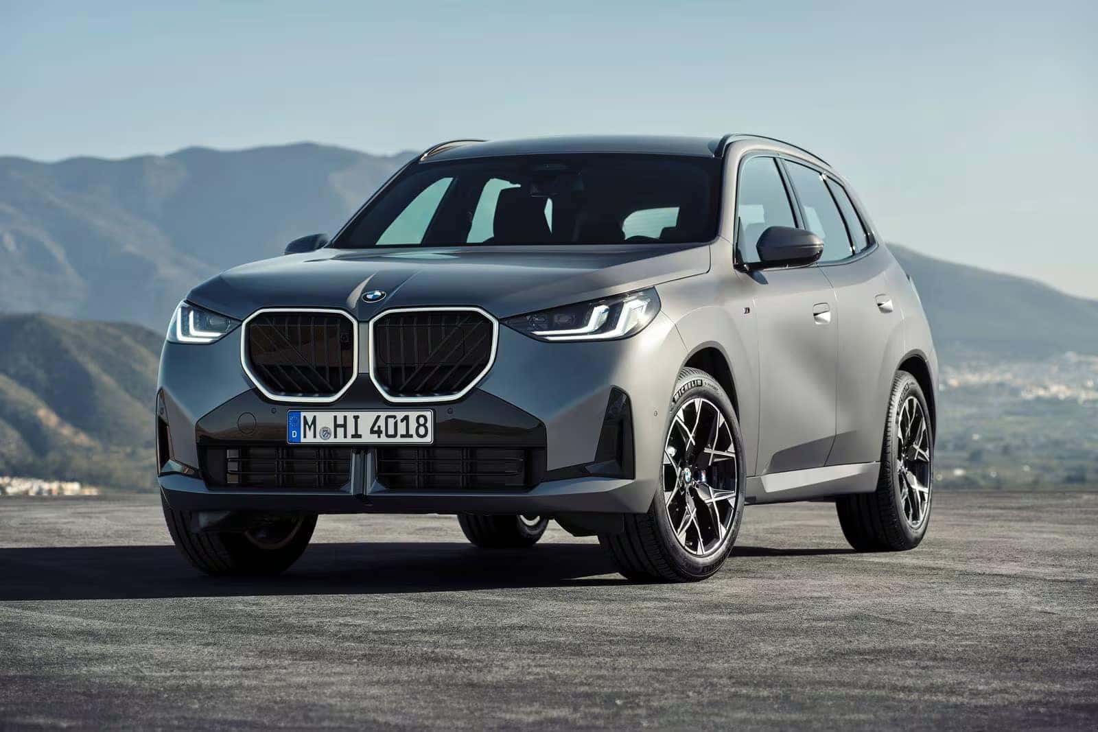 a new 2026 BMW X3 parked on a road with a mountain view in the back ground