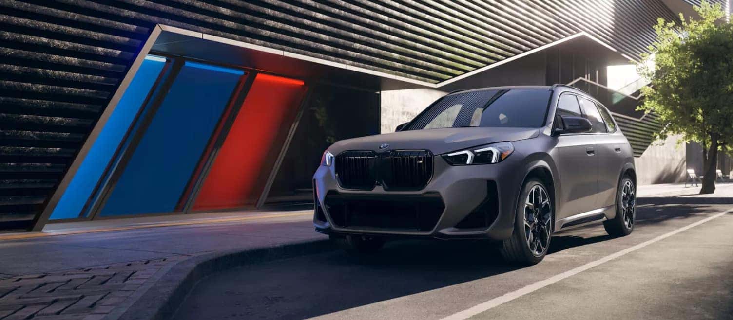 a grey 2026 BMW X1 parked next to a building