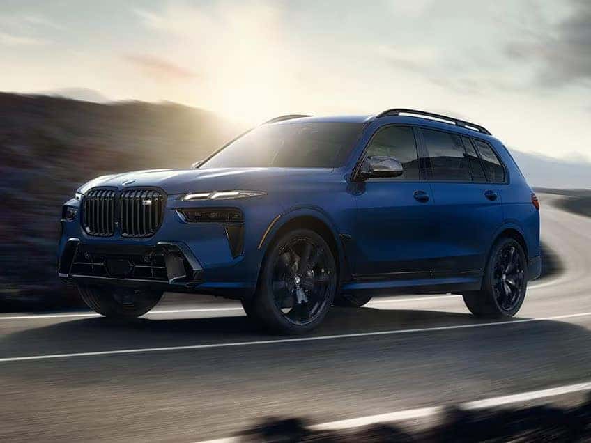 a navy 2026 BMW X7 Driving on a road