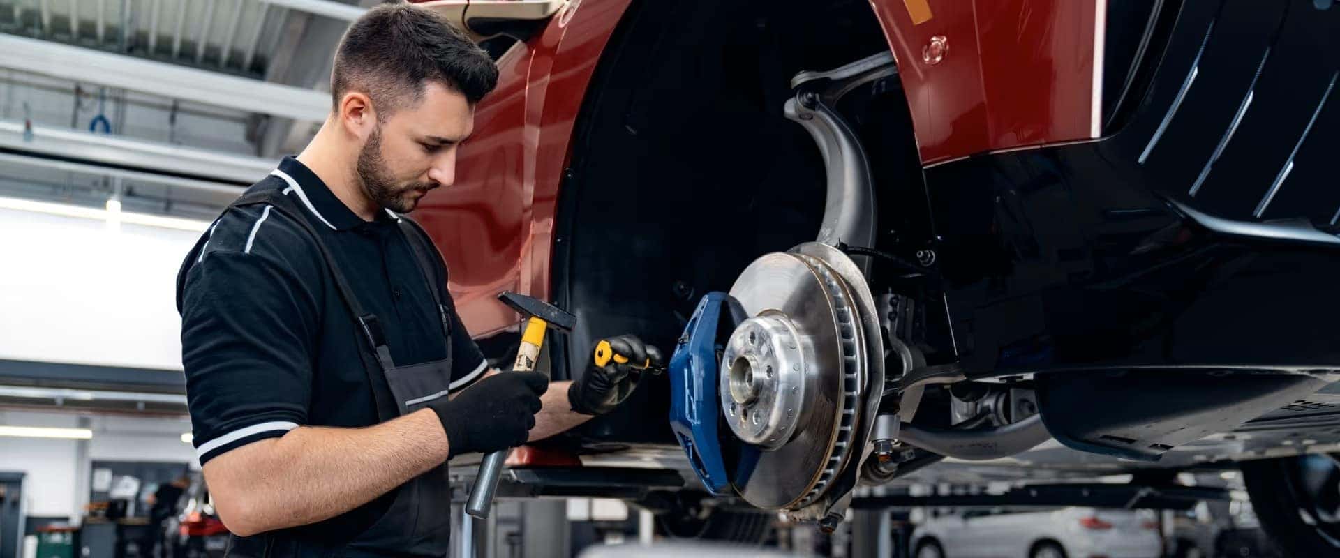 bmw technician working on an electric vehicle brakes