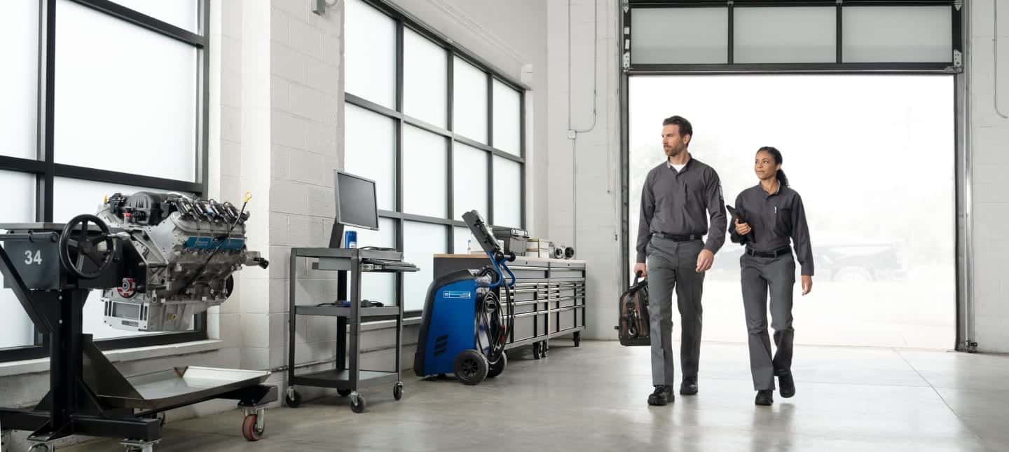 2 GM technicians walking in a service bay