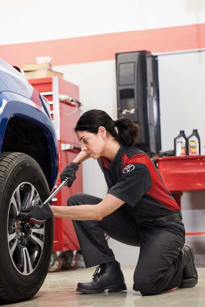 Woman performing Toyota service on a vehicle