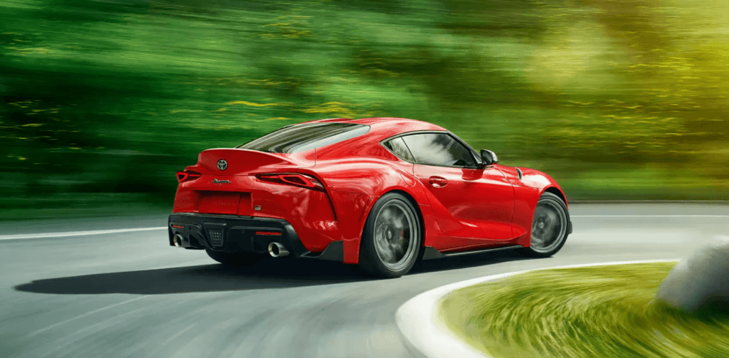 Side view of a red 2023 Toyota GR Supra handling a curve