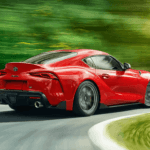 Side view of a red 2023 Toyota GR Supra handling a curve