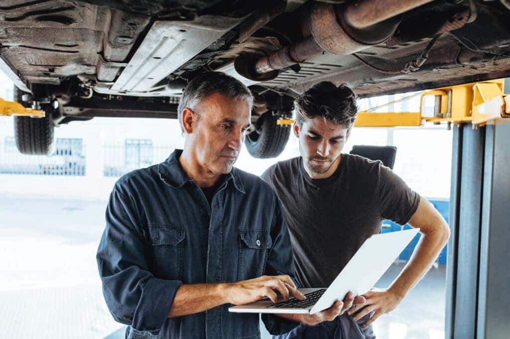 Technicians inspecting vehicle