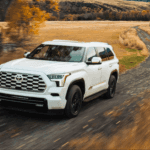 2026 Toyota Sequoia driving down a country road in fall